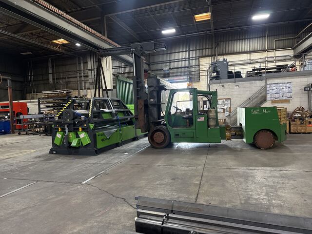 Carrying a new Gator plate-rolling machine to its foundation, shipping container still at the dock