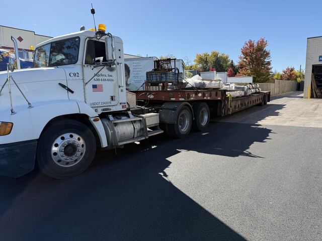 Our semi and step-deck loaded with machine sections, strapped and ready to leave