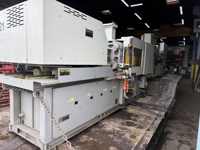 Plastic injection molding machine chained down on our lowboy for removal