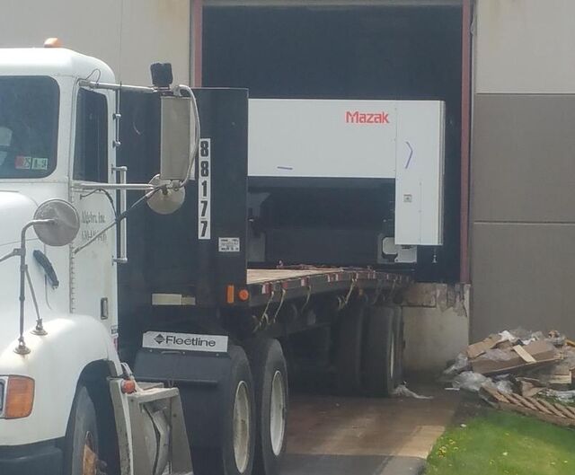 Backing a factory-new Mazak laser through an overhead door