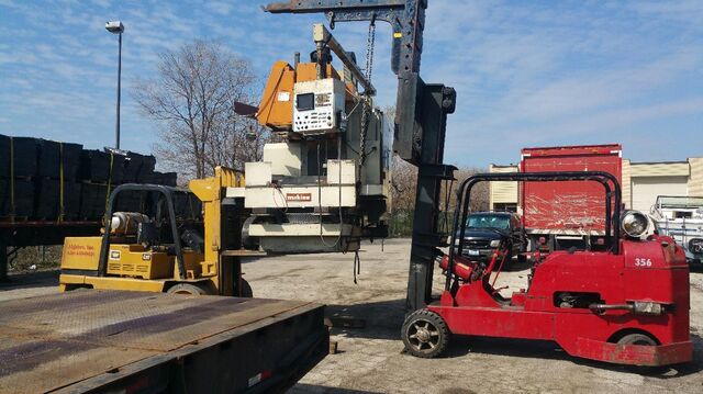 Tandem forklift pick: loading a Makino CNC mill onto the trailer