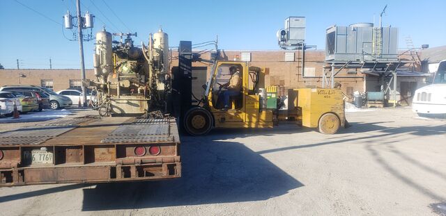Versa-Lift loading a machine onto a step-deck trailer