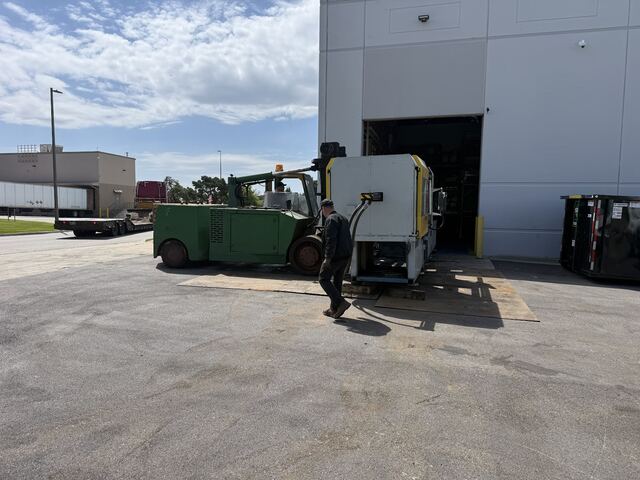 Carrying a machine out through the dock door on our Versa-Lift, straight onto the trailer
