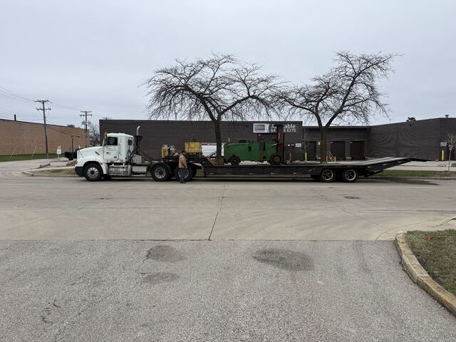 Our forklift rides out with the machine, both chained down on the lowboy