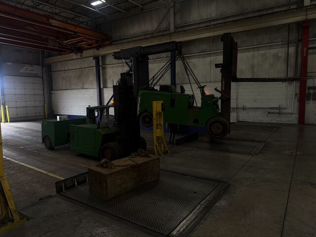 Rigging a machine onto chains under a Schaumburg plant's own overhead crane, our Versa-Lift taking the weight